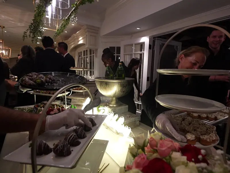Plated entrée being set down during an evening reception