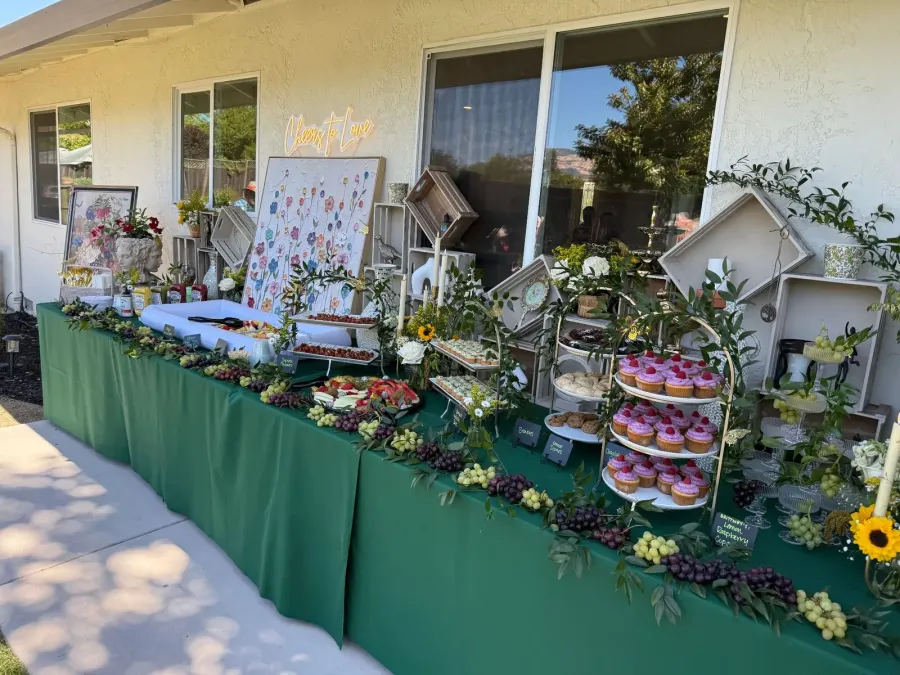 Shower tablescape of cupcakes, grapes and berries layered over soft draping and neutral cloths — shower styling for Pleasanton catering hosts near Livermore