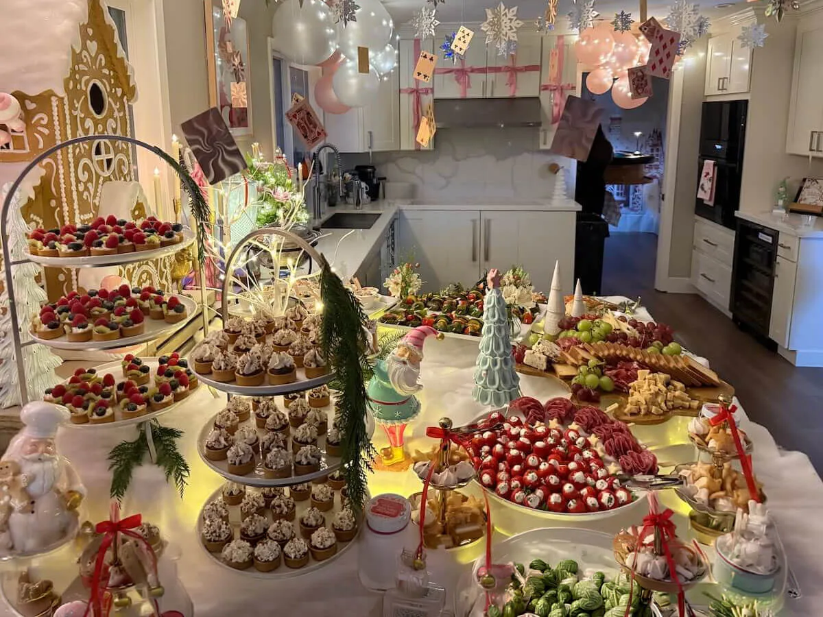 Styled celebration tablescape mixing tiered tarts, frosted cupcakes and charcuterie beneath pastel balloon decor — full tablescape design for Dublin catering parties