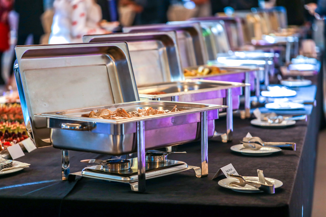 Stainless food containers on buffet table for prime rib catering